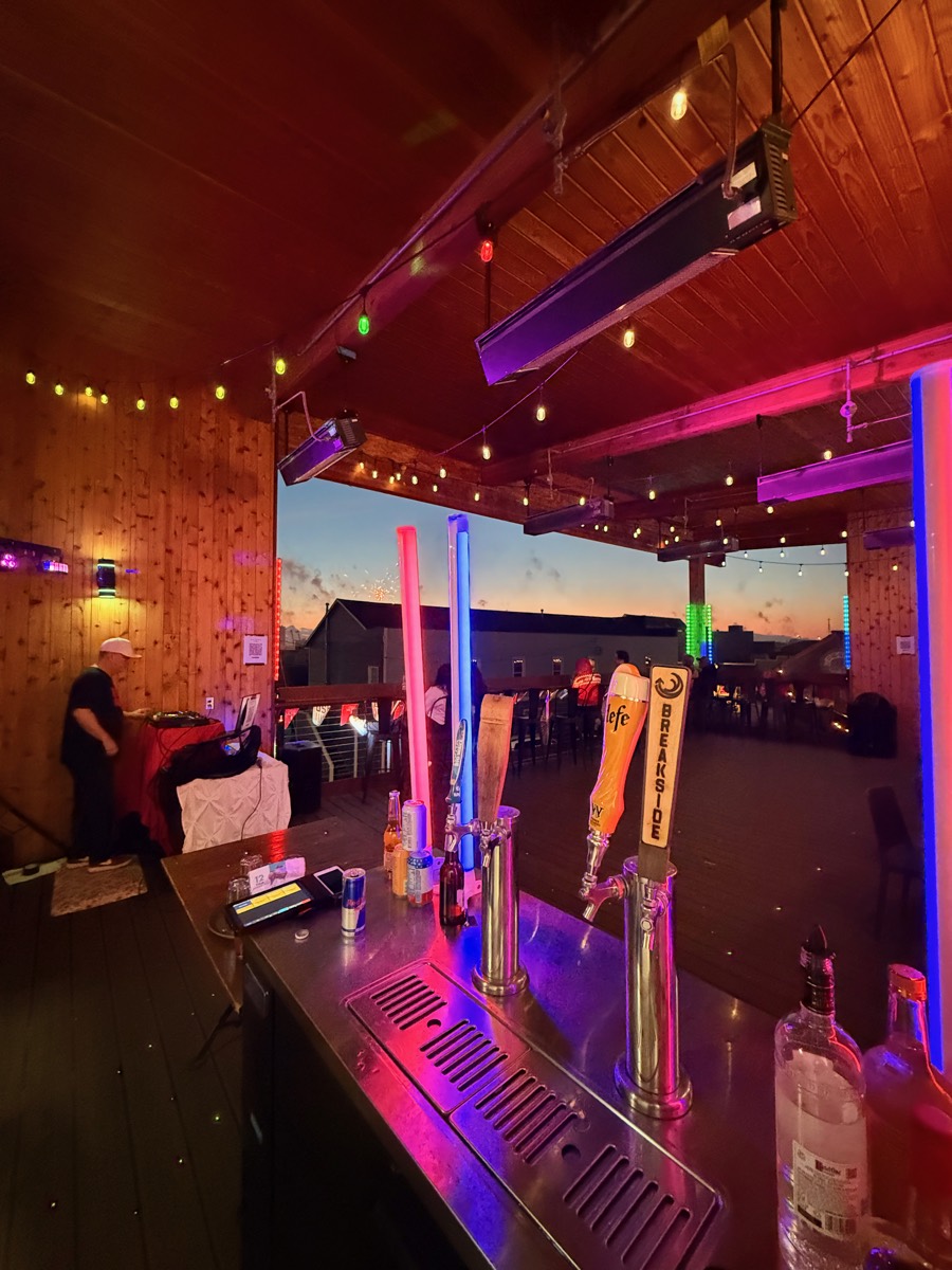Neon light columns and fireworks in the sunset sky